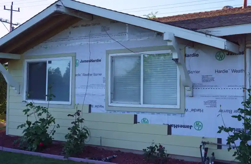 Close-up view of a home exterior with repaired siding panels blending with the existing siding