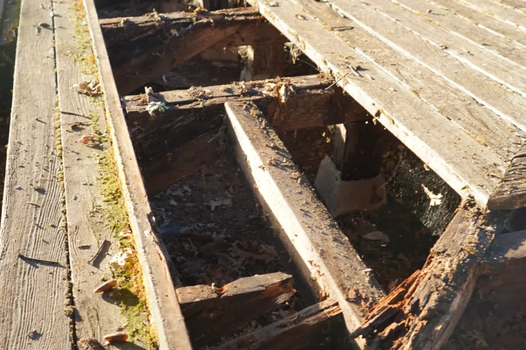 A homeowner standing beside an unfinished backyard deck project with visible construction issues