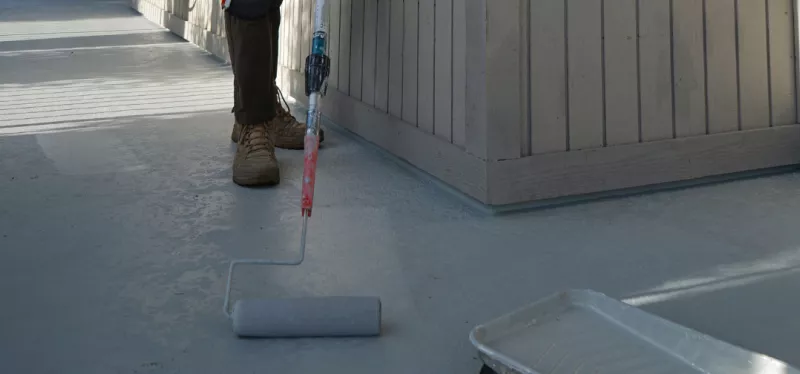 Elevated balcony deck being repaired with waterproofing protection and drainage improvements