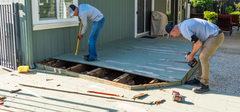 Contractor replacing worn deck boards on an existing residential deck