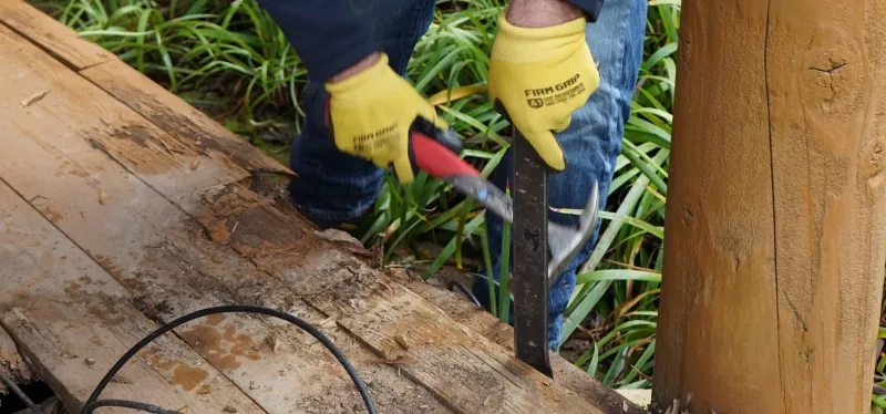 Contractor repairing rotted deck framing, joists, and structural supports