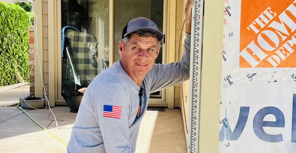 Contractor measuring siding on a Woodland home during an on-site estimate walkthrough
