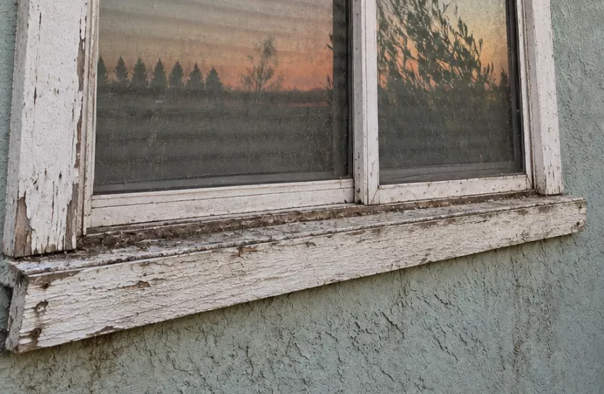 Weathered wood window sill with peeling paint on a Rancho Cordova home before replacement