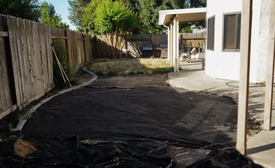 Empty backyard area prepared for a new Trex composite deck installation.