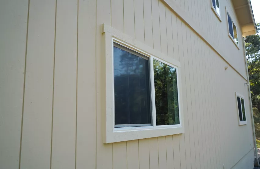 New slider window with fresh white trim and repaired siding after window replacement in Elk Grove