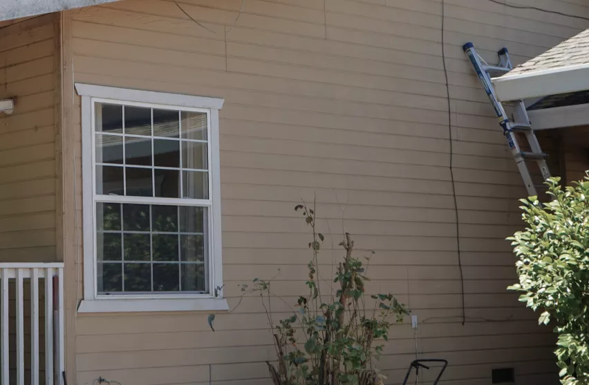 Roseville home side wall window before replacement with an aged white frame