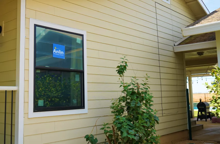 New black-framed Anlin replacement window installed on a Roseville home