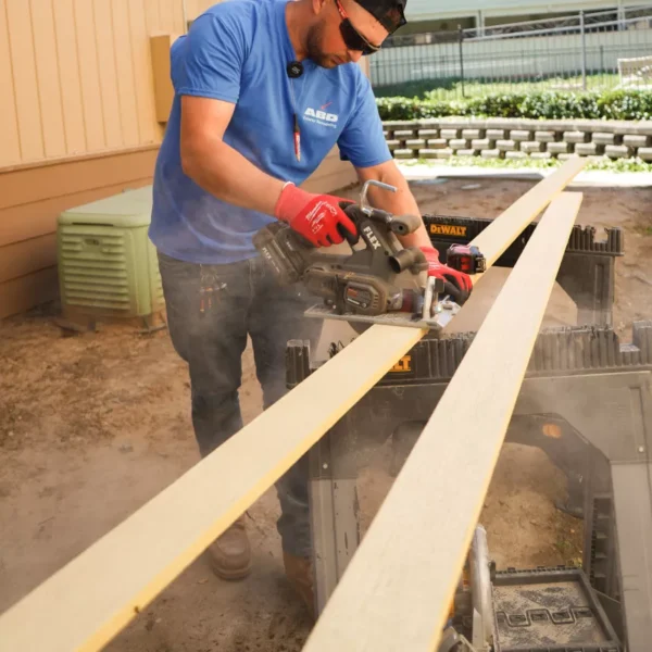 Crew member cutting deck boards during new Trex deck construction in Sacramento.