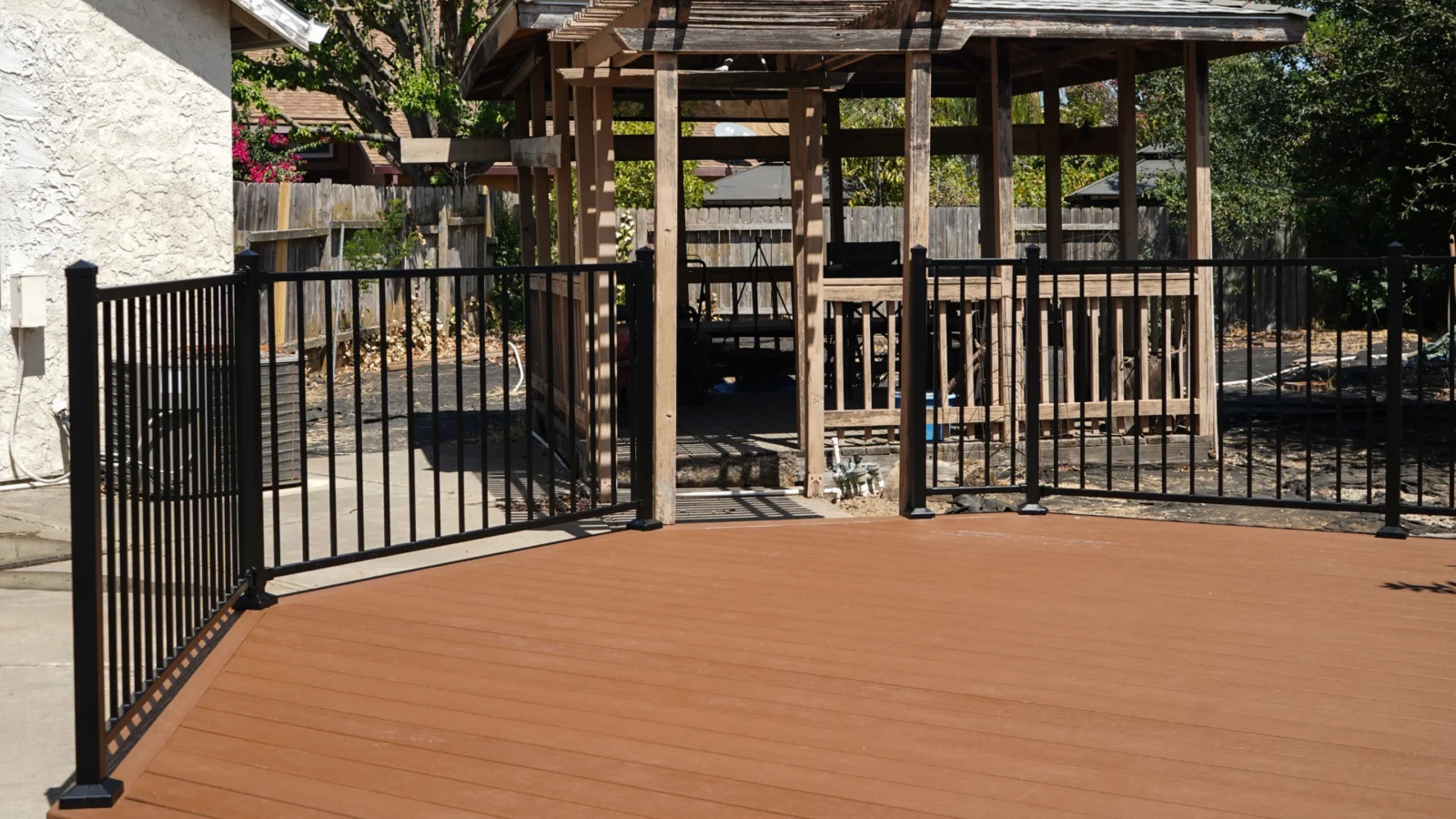 Completed small Trex deck with pergola in the background at a Sacramento home.